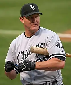 A man in a gray baaseball uniform and black cap