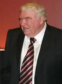 John Madden smiling, wearing a suit