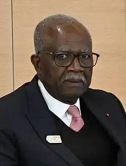 Headshot of Berre, wearing glasses, against a beige backdrop