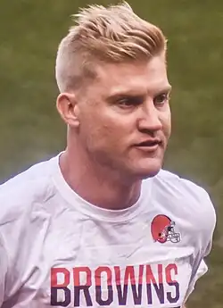 A photo of a Caucasian male wearing a white shirt with the word "Browns"