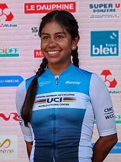 Juliana Londoño wearing a blue cycling jersey with white sleeves.