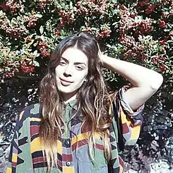 A photo of Byrne smiling in front of foliage