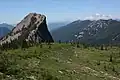 A rock outcropping immediately north of the summit of Jumbo Peak with Mount Rainier in the background