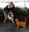 A sculpture of a woman feeding a cat