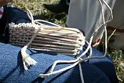 Close-up of a modern lapti-maker, using a wooden shoe last and cotton round braid. Most shoes of stiffer bast are woven on the bias, with strips running diagonally, but she is weaving on the grain, with braids running along the sole (see example, and both in one shoe)