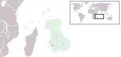 A map with four little green coloured islands in the middle surrounded by a light green area. On the upper right is a small world map using mercator projection. Mentioned islands are in the sea near the lower right side of Africa.