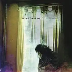 A man stares out of a window; the image colors are slightly distorted and the band and album title are printed near the top