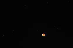 A wider angle shows stars around the moon.