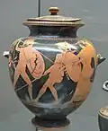Two warriors fighting with hoplite equipment: one is struck with a spear and falls back into a winged woman's arms