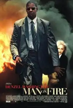 A man in a suit and sunglasses walking away from a fiery blaze, his arm held out to guard a small blonde girl