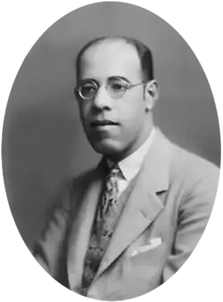 Black-and-white photograph showing the head and shoulders of Andrade. He is a middle-aged man with glasses wearing a suit.
