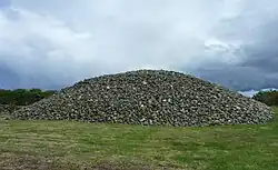 Large mound of stones in a grassy field
