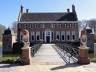 Brick building surrounded by a moat with a bridge