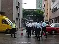 PTU officers cross a street toward police vans.