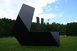 A geometric iron sculpture in a park outdoors