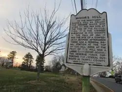 A historic marker located on top of the mostly flat summit of Minor's Hill.