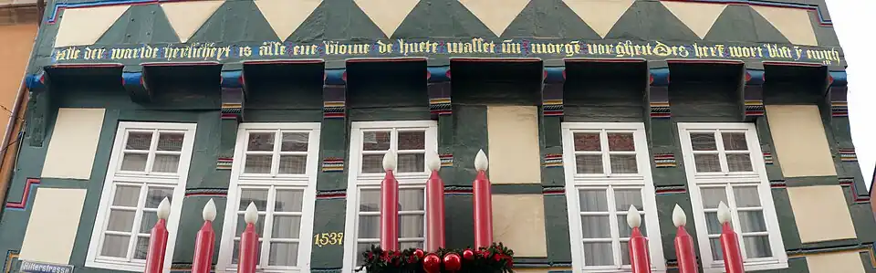 A Middle Low German inscription on a half-timbered house in Hameln, Lower Saxony that reads: Alle der warlde herlicheyt is alse ene blome de huete wasset un morge vorgheit. Des here wort blift y ewicheit. It is a passage from the First Epistle of Peter, and translates as 'All the world's magnificence is like a flower that grows today and vanishes tomorrow; the Lord's word remains in eternity.'
