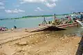 Bank of Oguta Lake showing human activities such as motorcycle washing and transportation of goods and people.