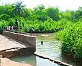 Swimming and washing of clothes being done at the river.