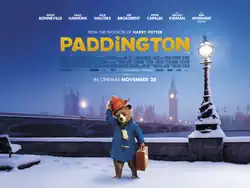 In a snowy London, Paddington Bear, seen with a blue jacket, a scarf, and a suitcase, lifts his red hat with his right hand.