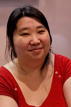 Patricia Lyfoung, a woman with black hair, a round face, and freckled skin, smiles at the camera