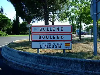 Entrance of Bollène. The second sign shows the town name in Provençal. The third one its twin town.