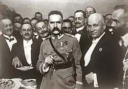 A crowd of men dressed in tuxedoes and military uniforms