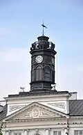 Tower with clock, weathervane, pediment, and columns