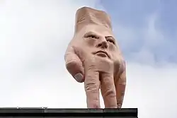 A statue of a disembodied hand with a face on it.