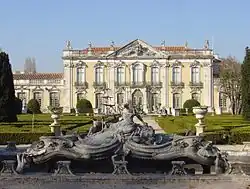 The front façade of the Queluz National Palace with ornate water fountain