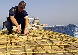 Image 90A sailor from HMAS Adelaide inspecting a ship in the Persian Gulf during 2004 (from History of the Royal Australian Navy)