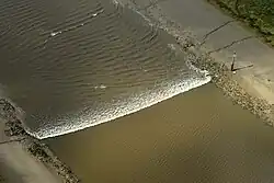 A tidal bore wave moves along the River Ribble between the entrances to the Rivers Douglas and Preston.