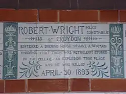 A tablet formed of six standard sized tiles, bordered by green flowers in the style of the Arts and Crafts movement