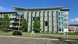 A multistory building made with glass and grey stone in a modern style.