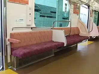 Tip-up seat for wheelchair space