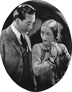 Black and white film still showing a man and woman in Asian period costume