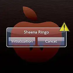 A digitally drawn red apple. In front of it is a computer prompt in the style of an Apple prompt, asking the used if they want to initialize of cancel Sheena Ringo.