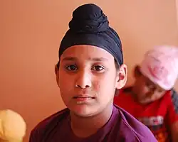 A Sikh boy with a rishi knot wearing a patka.