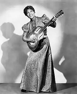 On stage, Tharpe sways to her right, guitar in hand, smile beaming, with the spotlight on her.