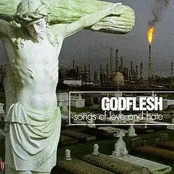 A photograph of a crucifix gravestone with a factory in the background, taken in Cancer Alley, Louisiana