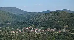An overhead view of the village Spahići, which is surrounded by green hills.