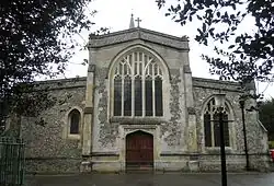 Very large arched window above a large wooden door