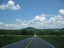 View of a long paved road and a mountain in the distance.