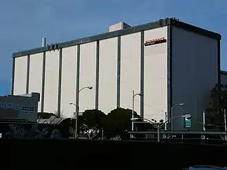 A multistory, windowless white building in an urban environment, with the words "Sundance Cinemas" on the side.