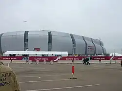 photo of State Farm Stadium taken from the parking lot, showing the domed stadium against an overcast sky