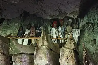Toraja tau tau (wooden statue of the deceased) in South Sulawesi, Indonesia (also note the boat-shaped coffins)