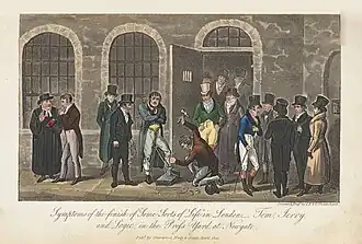 Outdoor scene in front of a prison: a prisoner is being put in irons while other people stand and watch