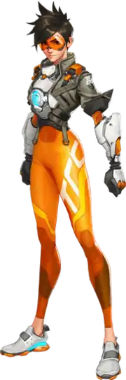 An illustration of a young, Caucasian woman with spiky, brown hair. She is wearing orange goggles over her eyes, a brown jacket, a blue lamp on her abdomen, brown gloves and orange leggings. There is some augmentation of the arms. She stands slightly angled, but facing the viewer with both of her hands clenched into fists and arms straight down to her sides.