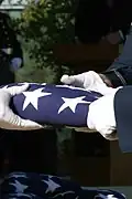 An Air Force honor guard folds the American flag after presenting it to the families of the first veterans buried.