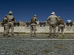 A USMC marksmanship instructor watching marksmen engage targets during the Combat Marksmanship Coaches Course at MCAS Miramar in 2015